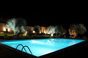 Una piscina al aire libre de temporada, sombrillas