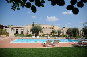 Una piscina al aire libre de temporada, sombrillas