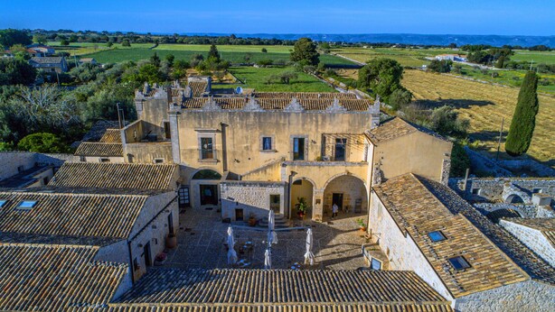 A historic building with a courtyard, stone walls, and tiled roofs. - Torre Don Virgilio Country Hotel (Modica)