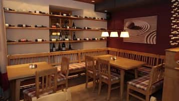 Ein gemütliches Restaurant mit Holztischen, Regalen voller Flaschen und einer Wand mit Muster.