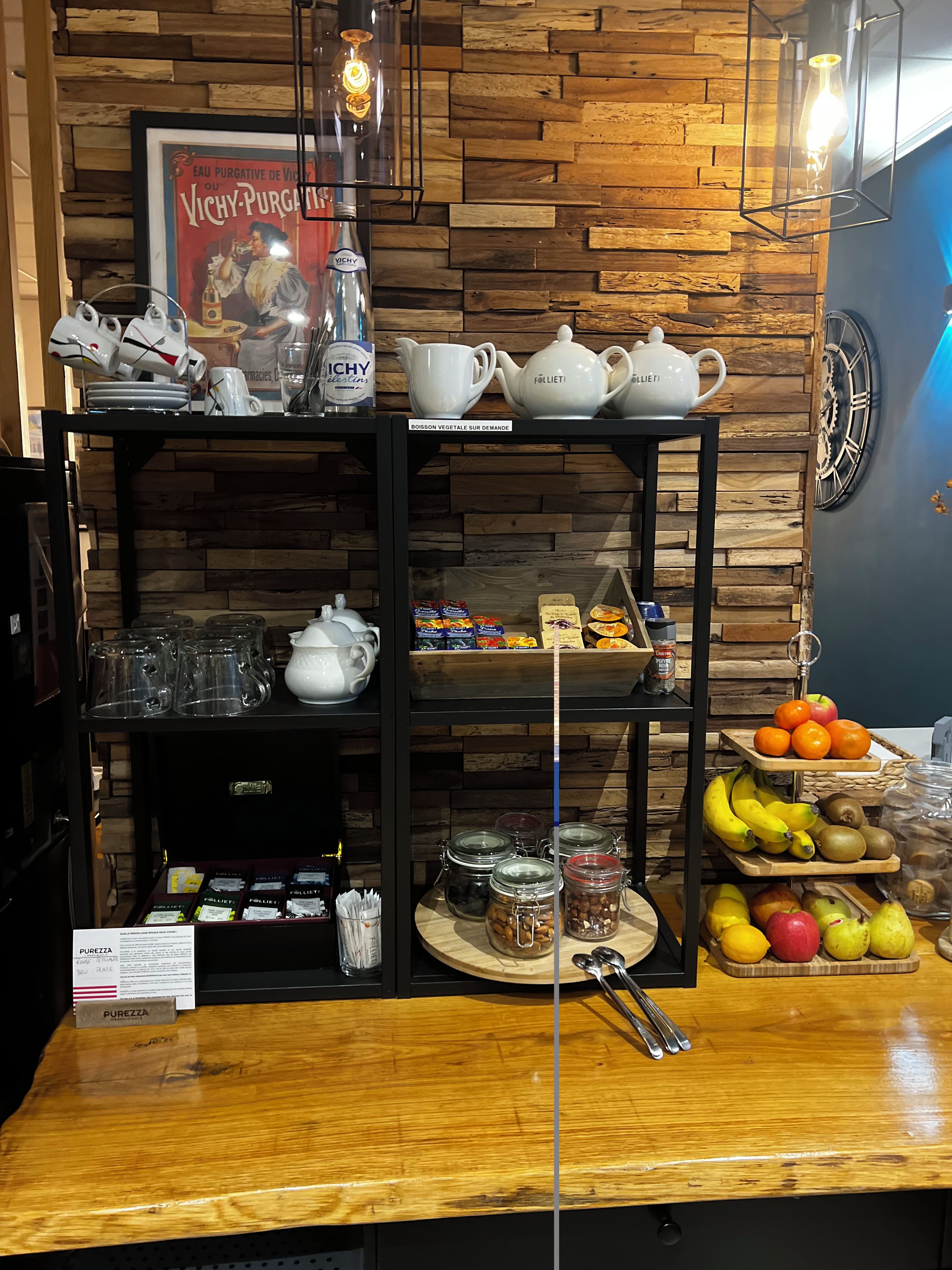 Ein Café-Interieur mit Holzwandverkleidung, einem Vintage-Poster und einer Auswahl an Tee- und Kaffeeprodukten auf Regalen.