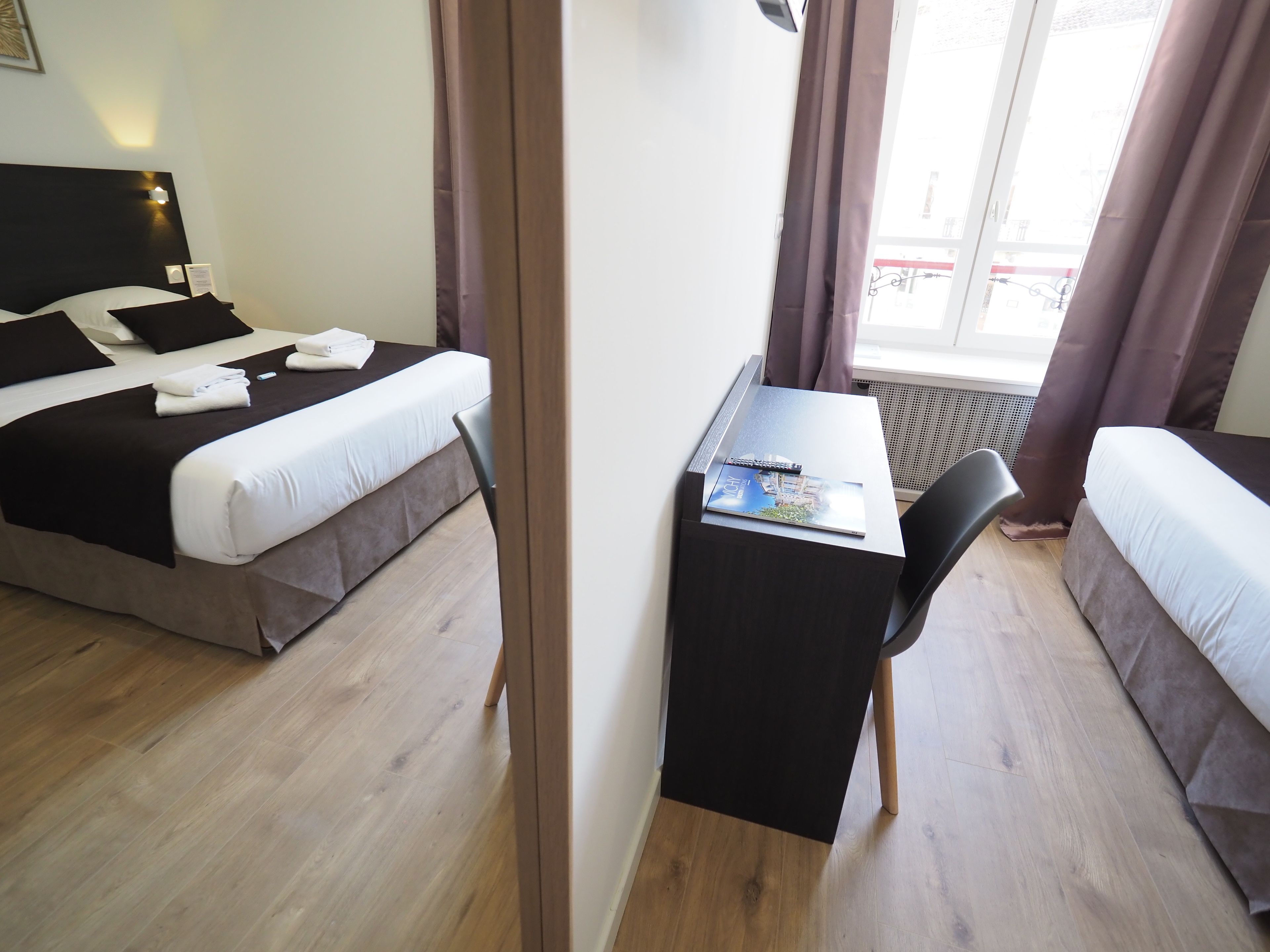 Una habitación de hotel con cama, escritorio y silla.