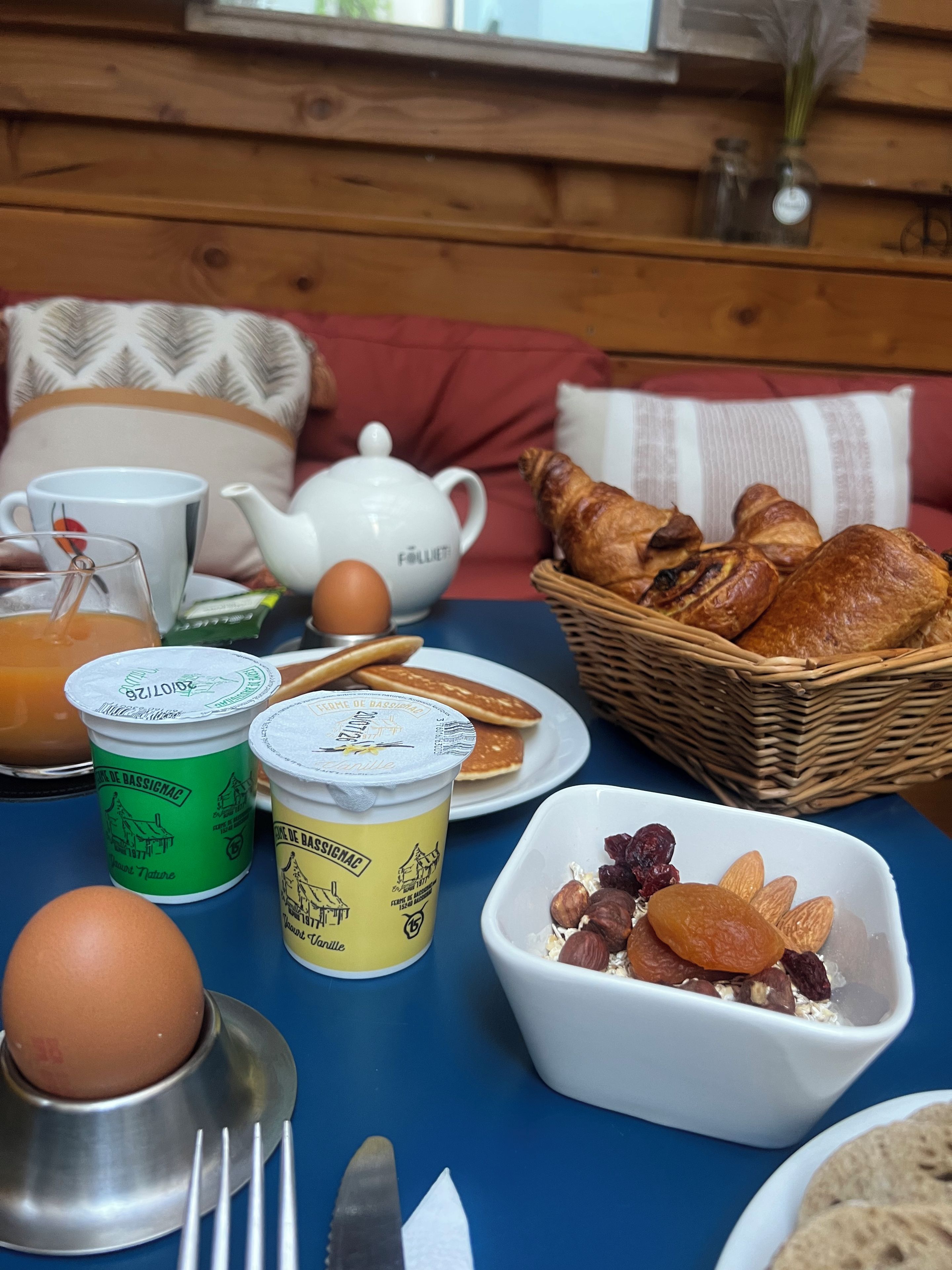 A breakfast table with eggs, pastries, and dairy products.
