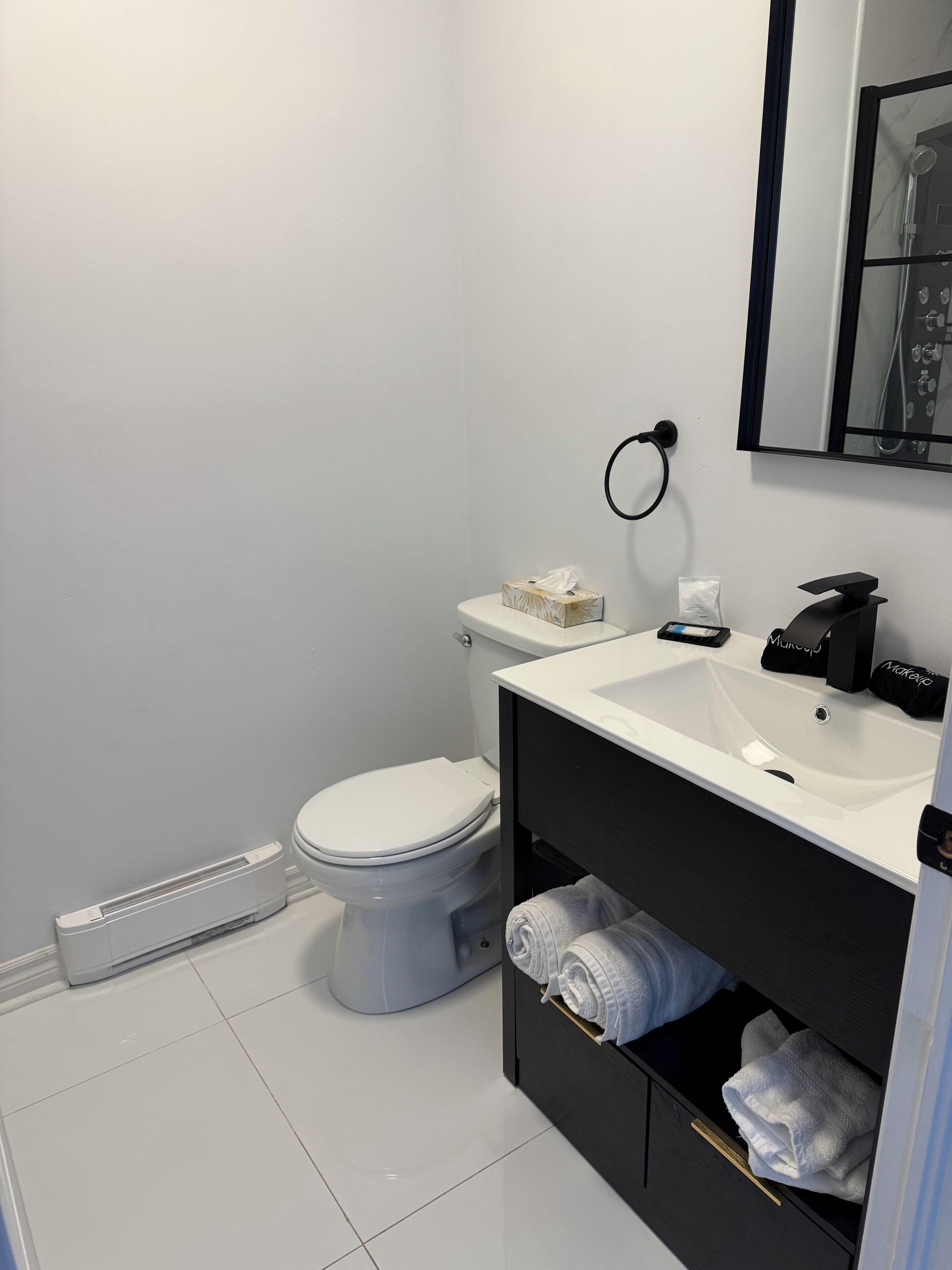 Un bany modern amb vàter, rentamig i paraigua per tovalloles.