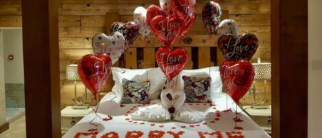 A bed with a 'MARRY ME' message and heart-shaped balloons.