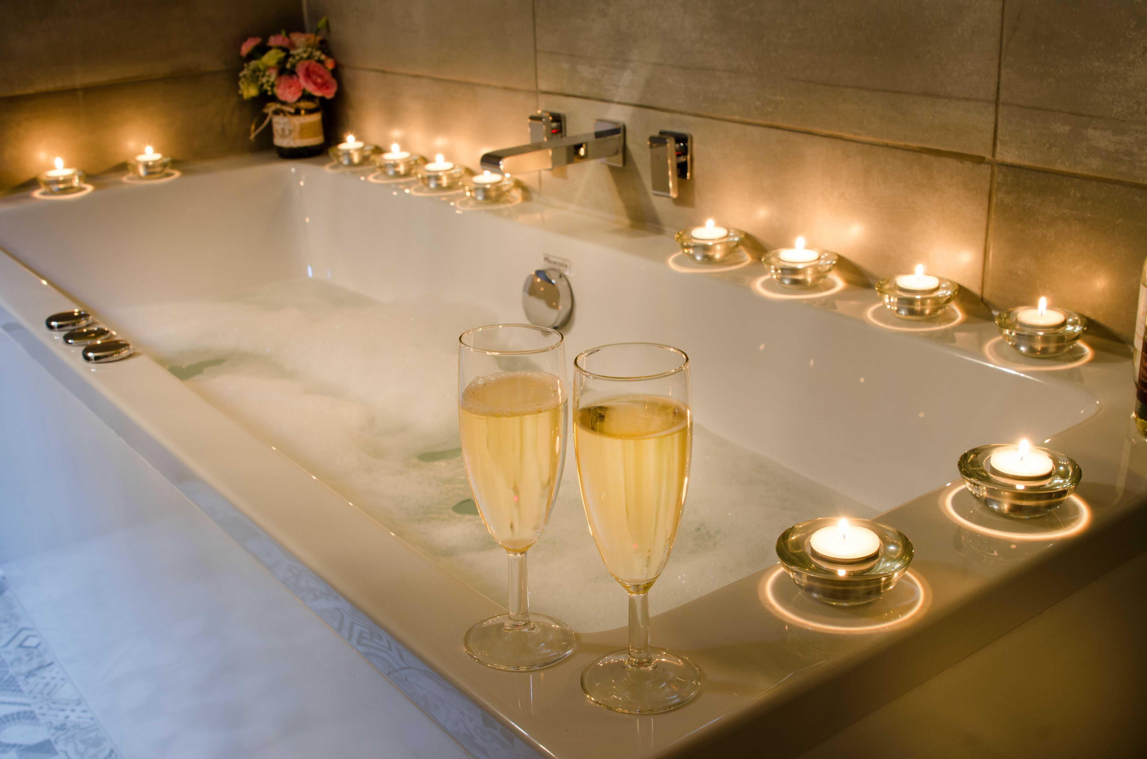 Eine Badewanne mit Champagnergläsern und Kerzen.