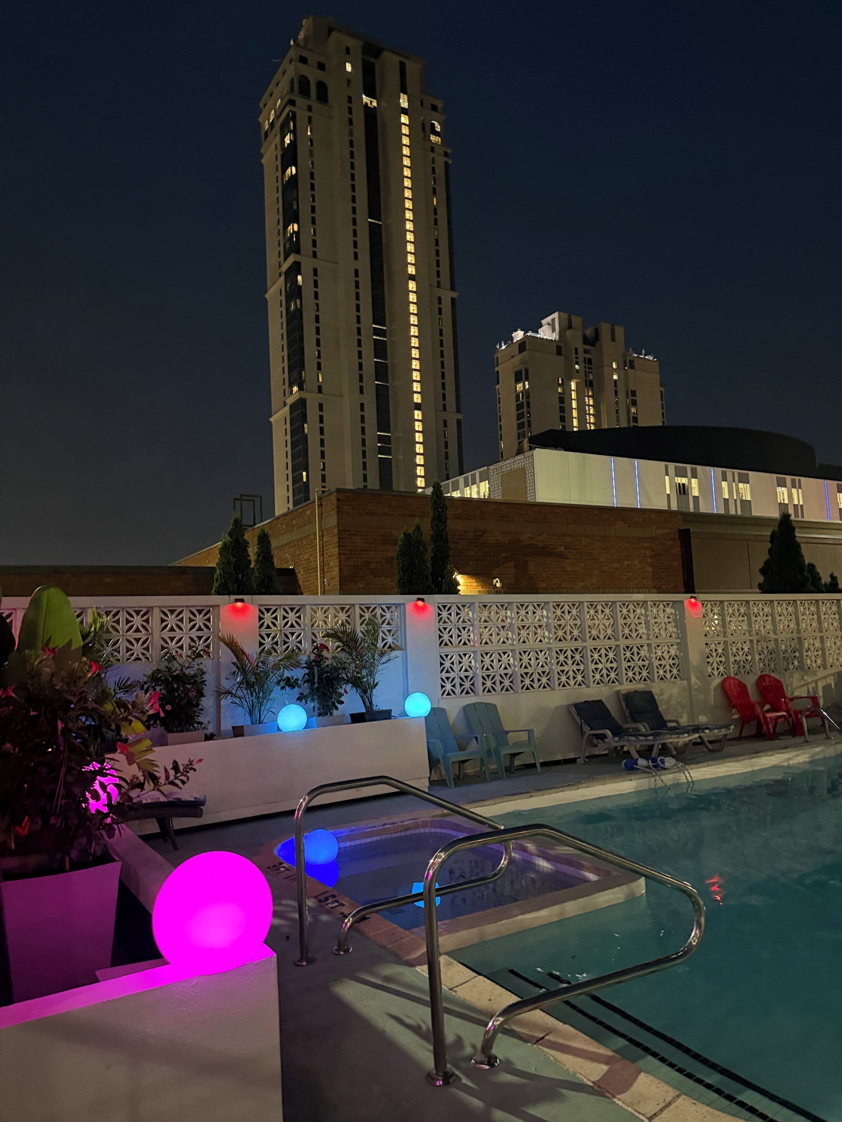A swimming pool area with lounge chairs and a poolside railing.