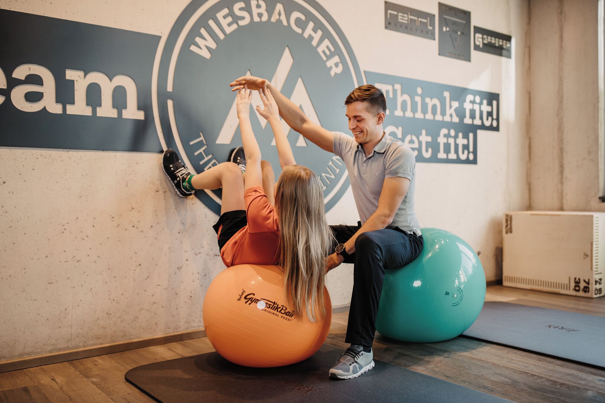 A gym with exercise balls and a wall with motivational text.