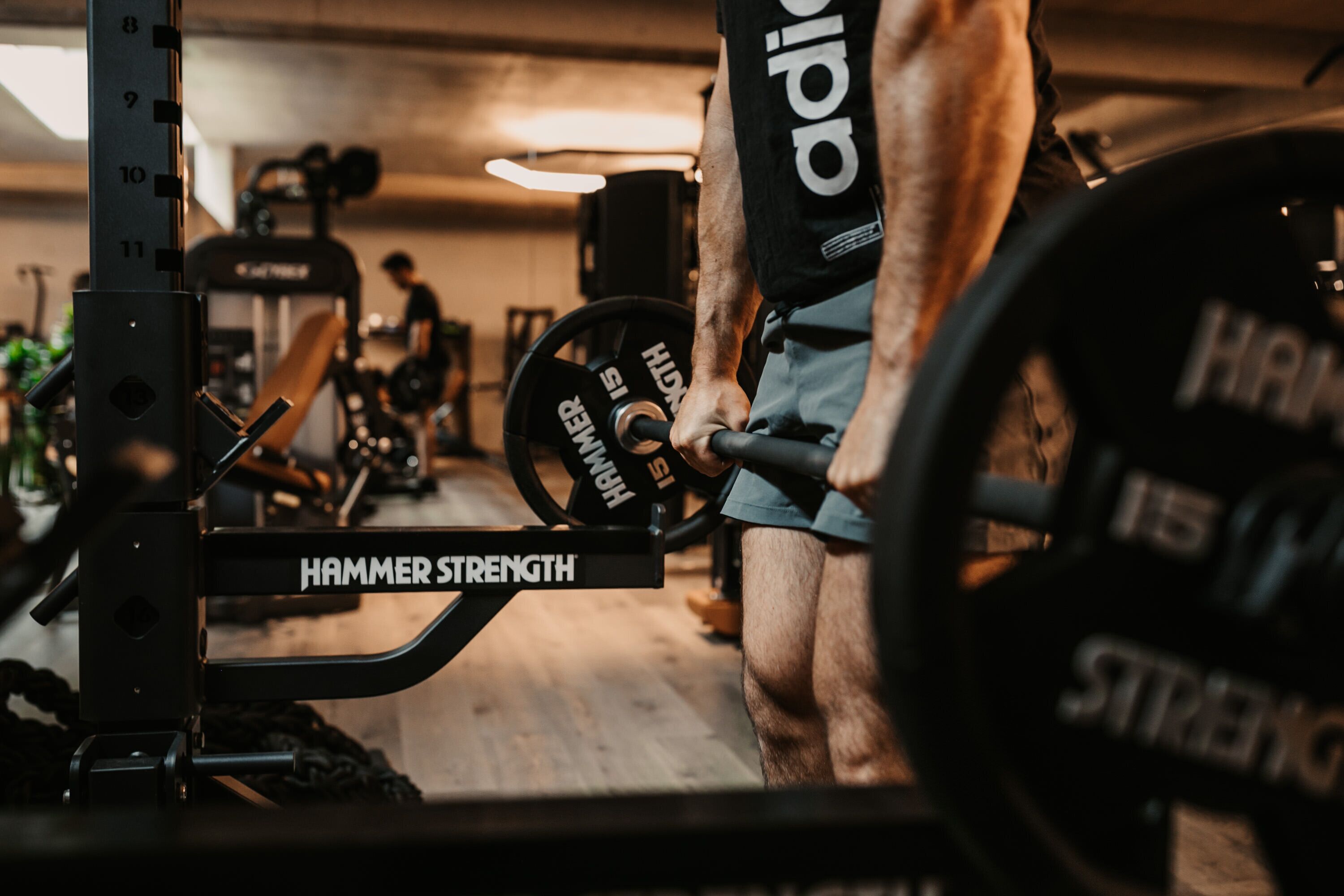 A gym environment with weightlifting equipment, including a barbell and weight plates.