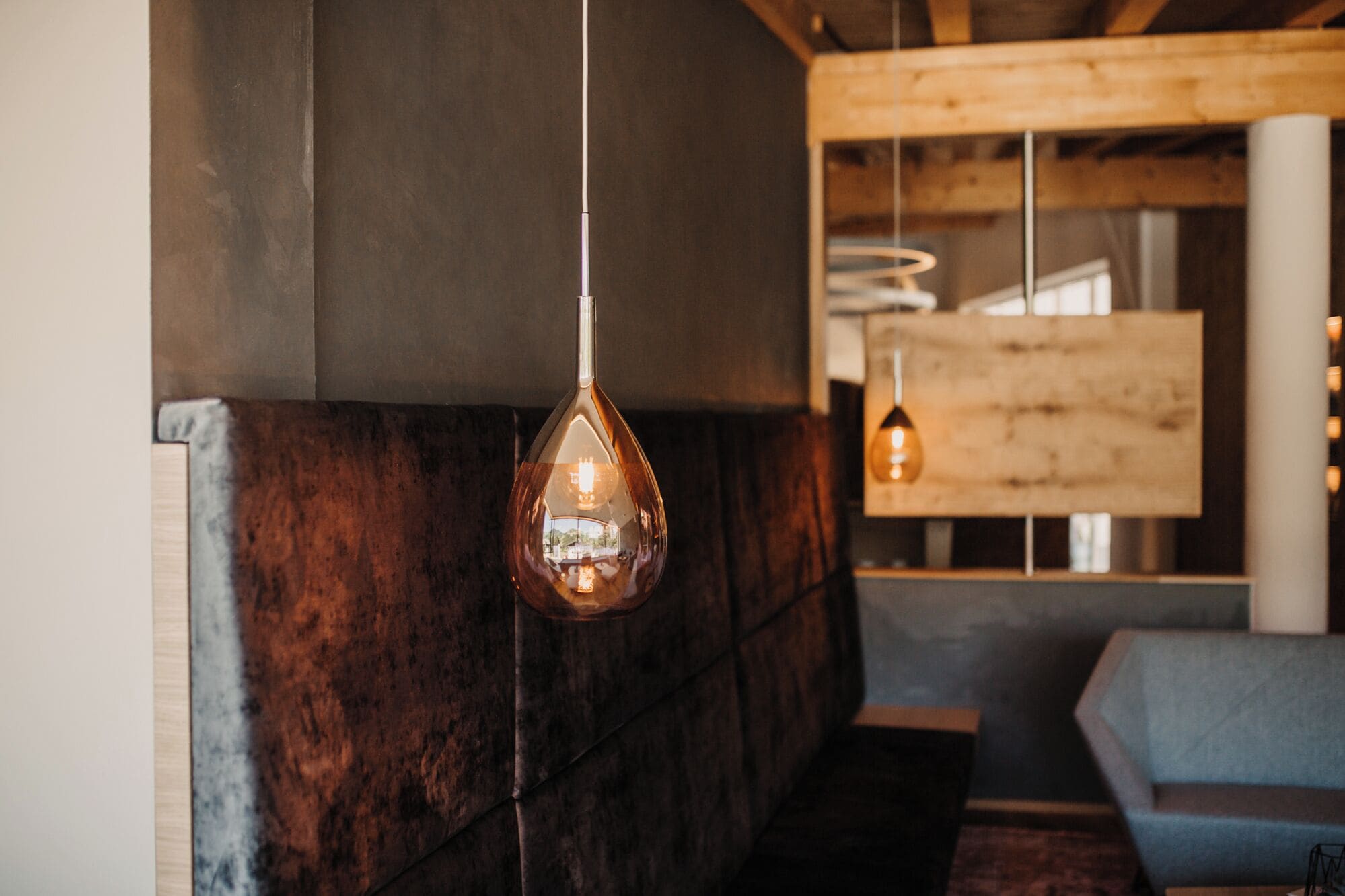 Ein modernes Interieur mit einer hängenden Leuchte und Holzelementen.