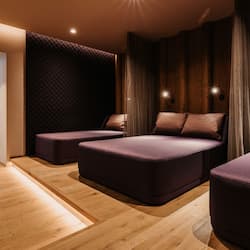 Relax in a stylish room with a sectional sofa, wooden floor, and glass door leading to an outdoor area.