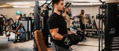 A gym with various exercise equipment, including dumbbells and weight machines.