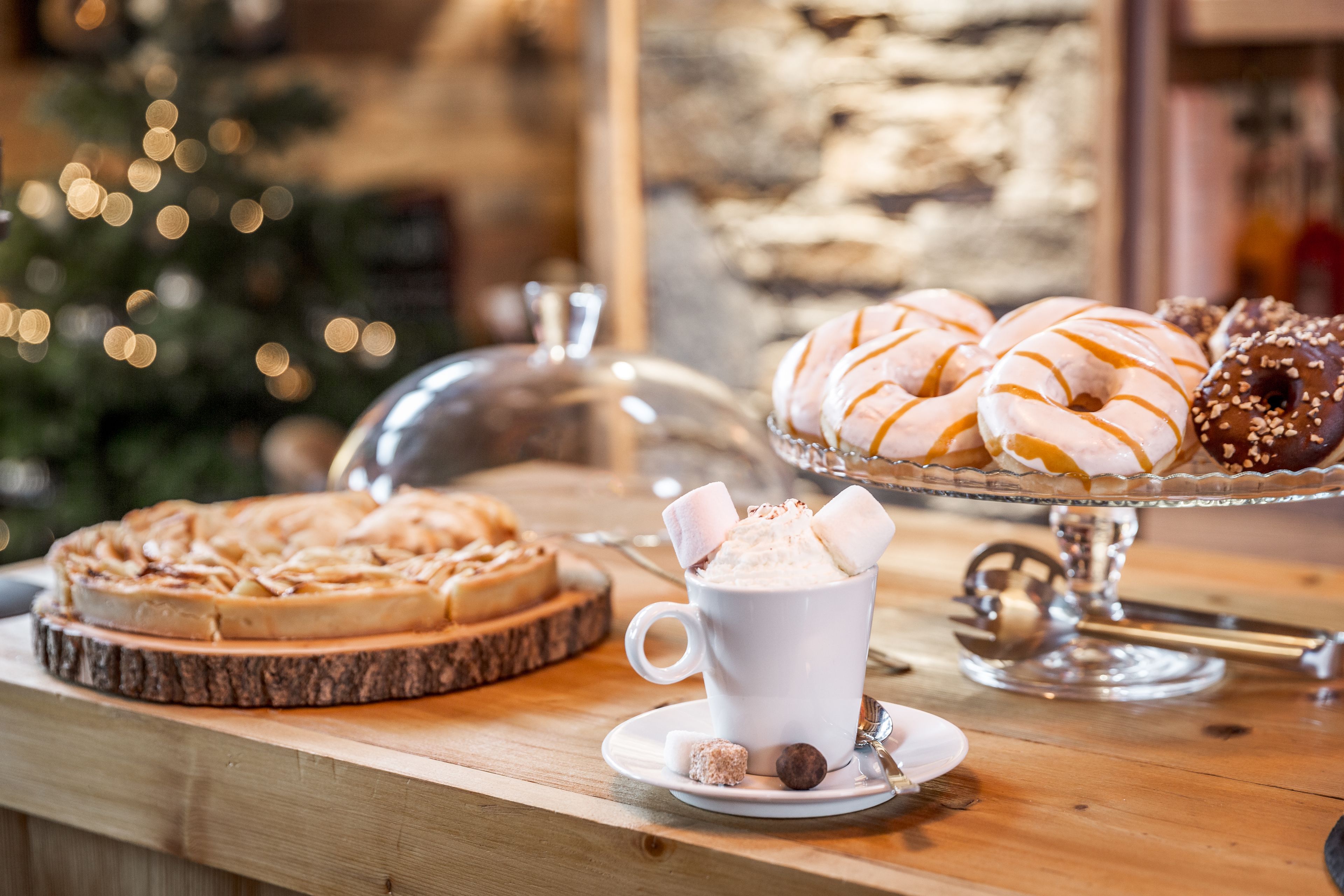 A dessert table with a variety of pastries and a cup of hot chocolate.
