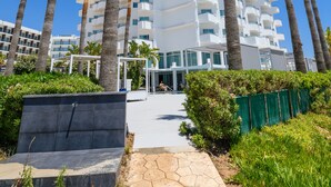 A modern hotel with multiple floors, palm trees, and a clear blue sky. - Tasia Maris Sands - Adults Only (Ayia Napa)