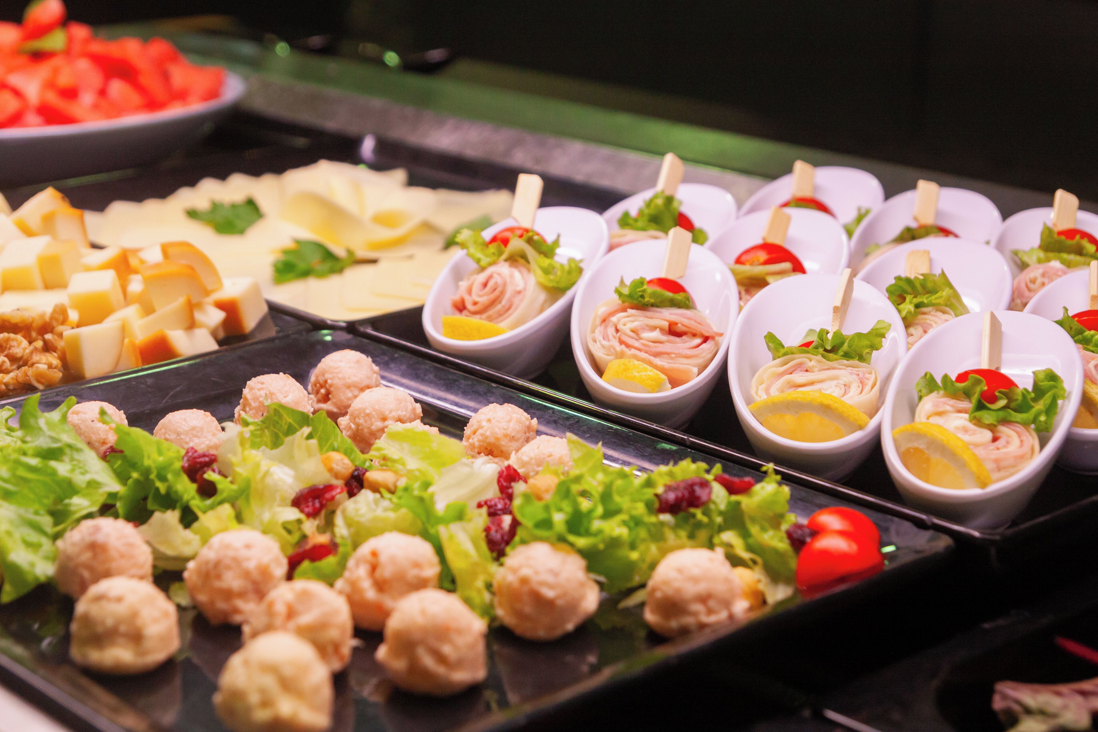 Ein Buffet mit verschiedenen Speisen, darunter Salate, Fleisch und Käse.