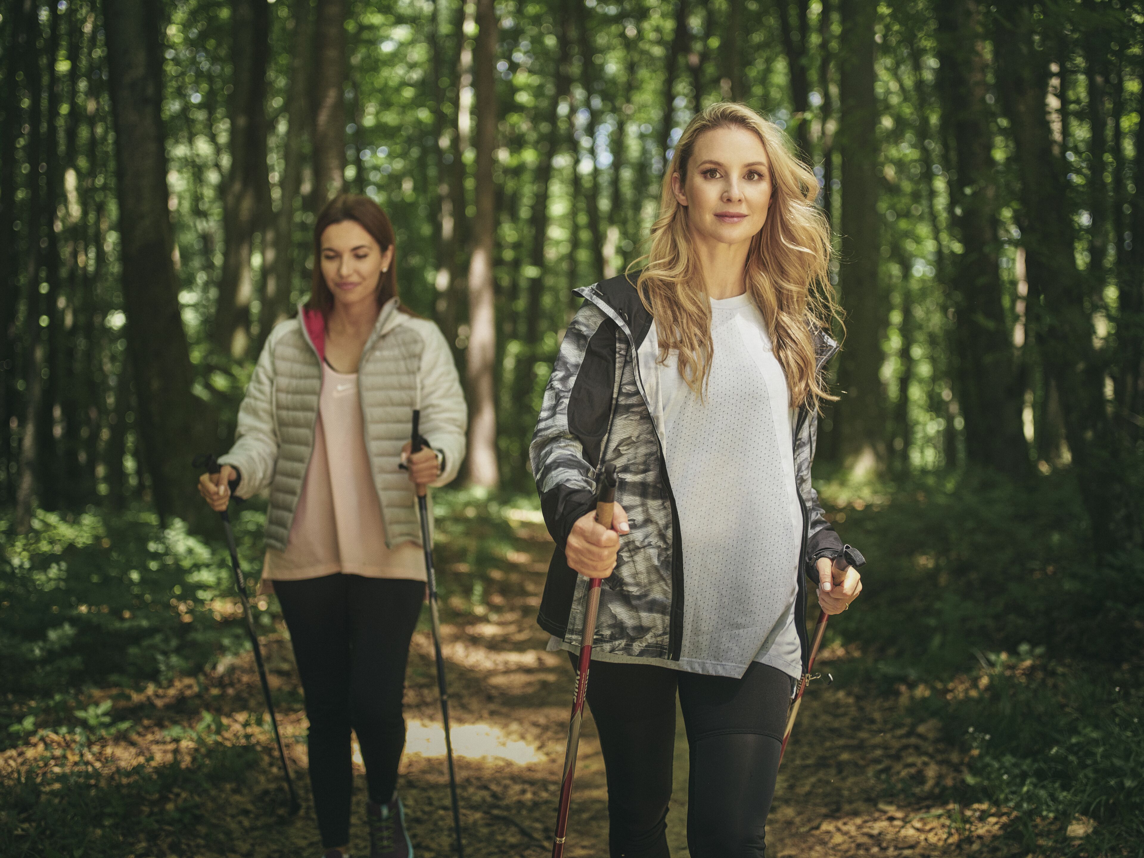 Two people hiking in a forested area.
