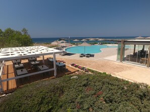 A resort with a pool area, outdoor seating, and a view of the sea. - Kavos Hotel (Chania)