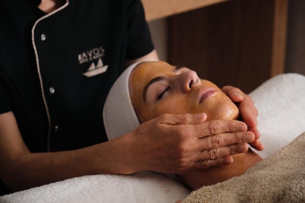 A person receiving a facial treatment in a spa setting.