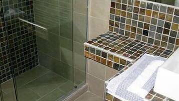 Une salle de bain avec une douche à parois de verre et un meuble-lavabo carrelé.