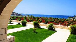 An arched pathway leading to a view of the sea. - Kavos Hotel (Chania)