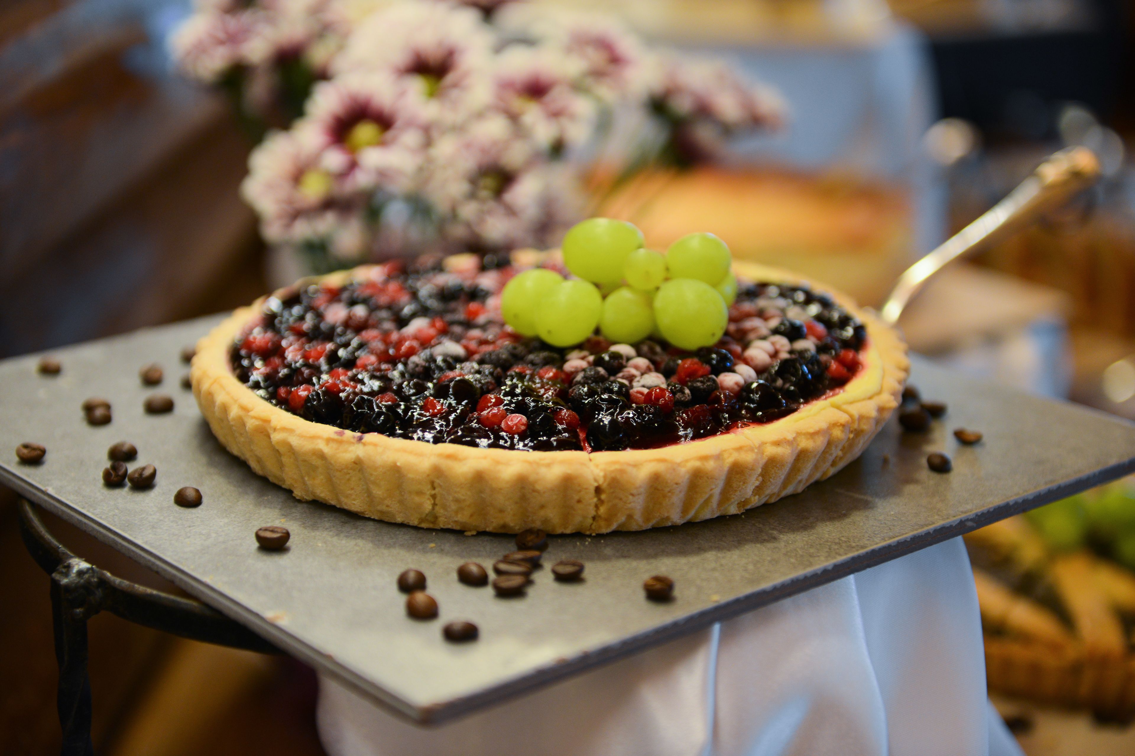 A dessert on a plate with a spoon, surrounded by scattered coffee beans.
