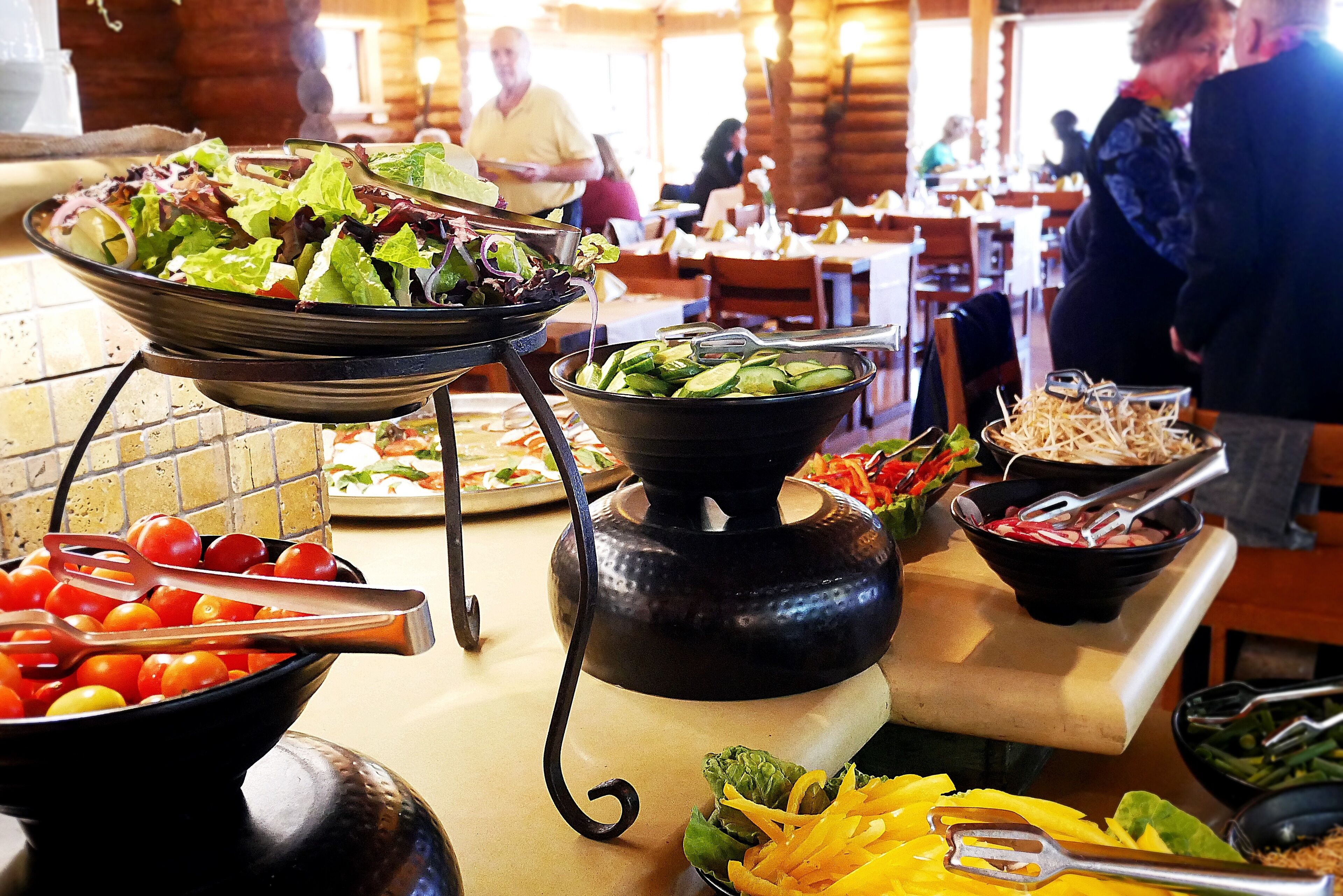 A buffet setup with various food items and utensils.