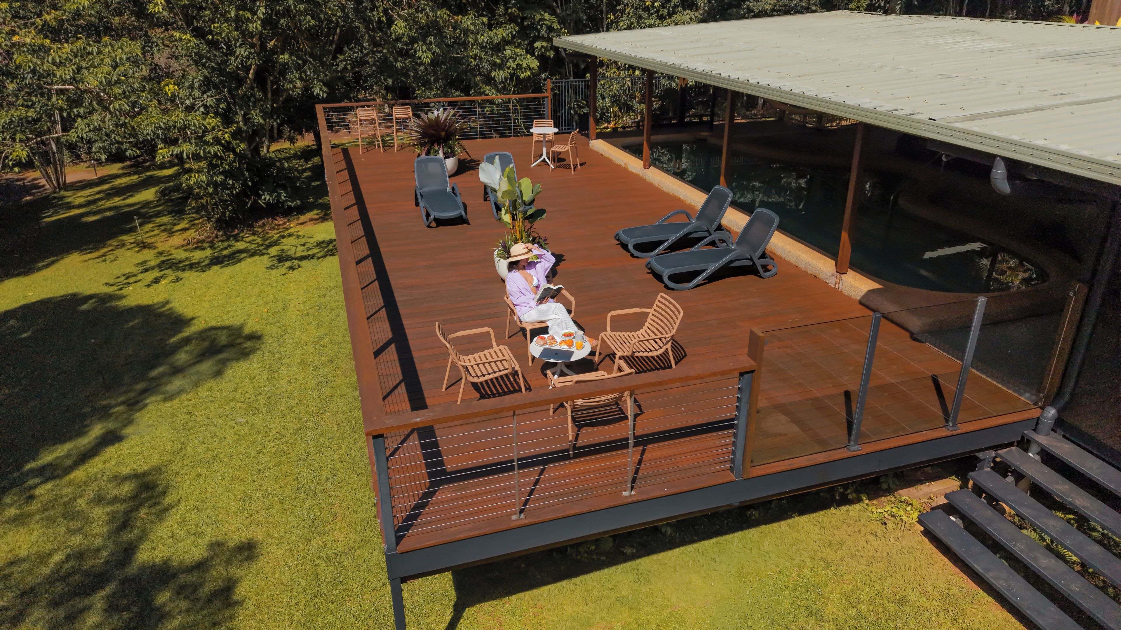 A deck with outdoor furniture, a dining table, and a water feature.