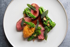 A plate of food with various vegetables and a piece of meat.