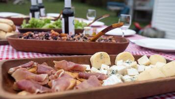 Una mesa con diferentes alimentos, incluyendo carnes, quesos y aceitunas.