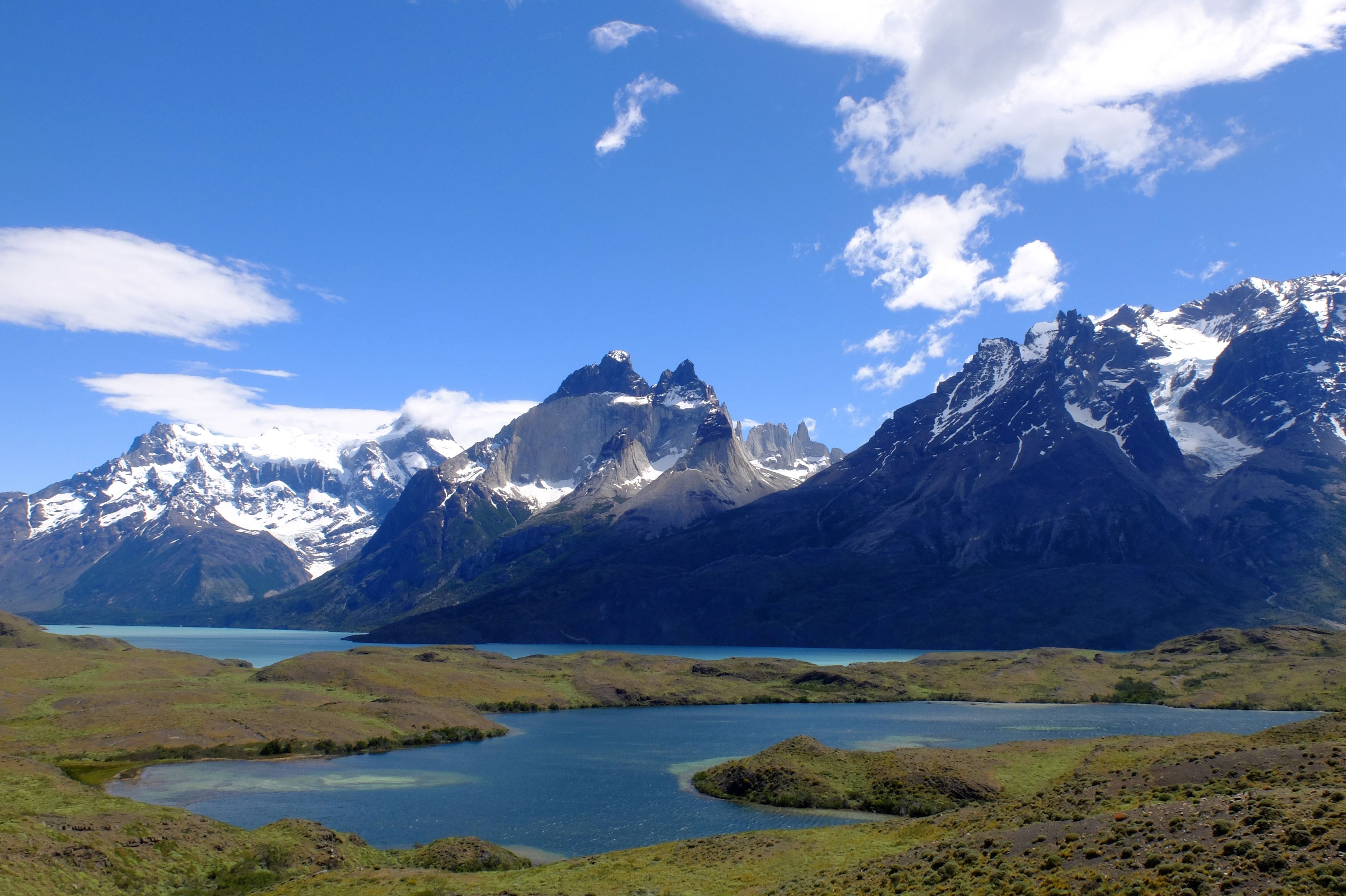 A mountainous landscape with a lake and snow-capped peaks.