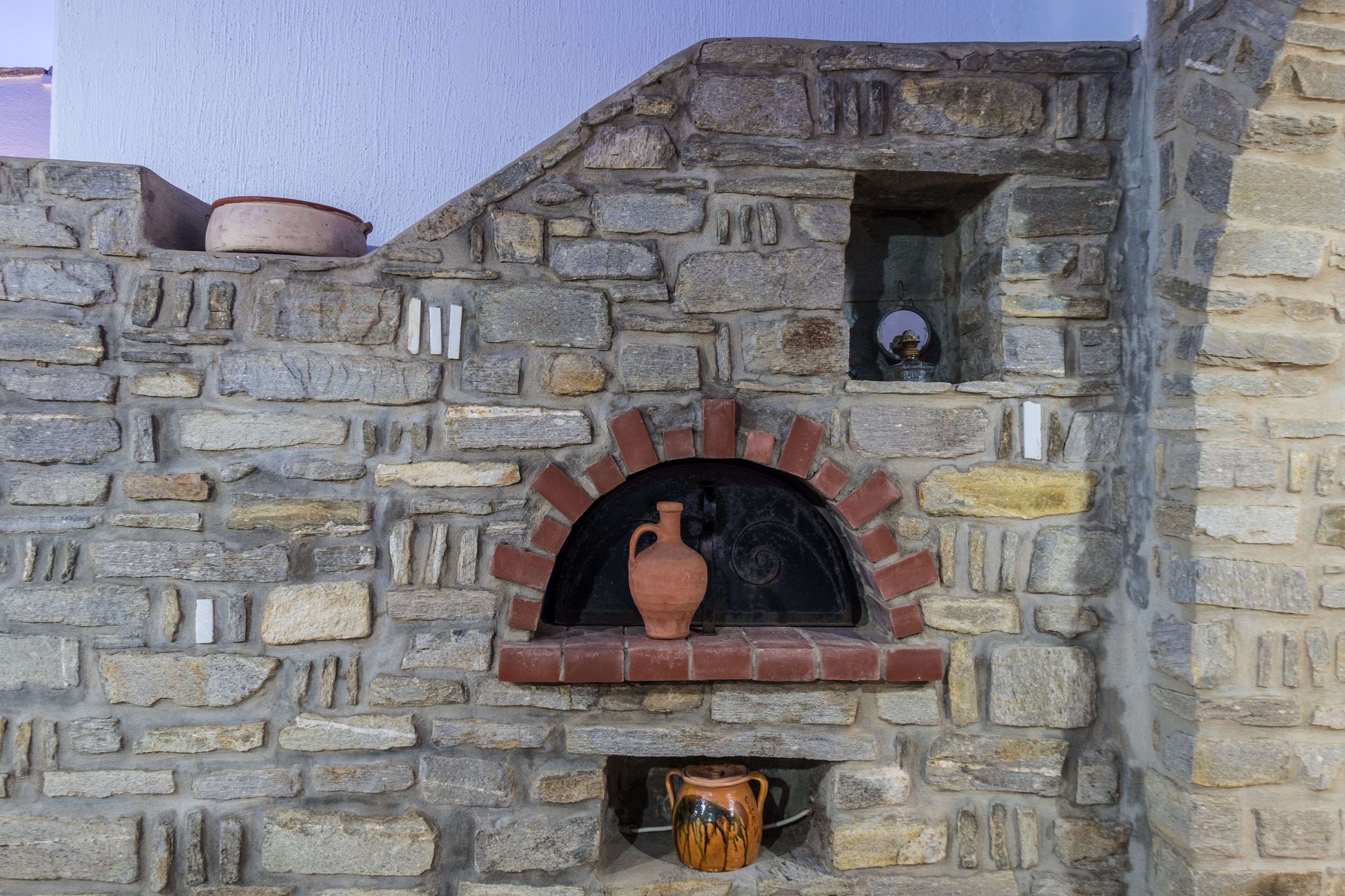 Un mur de pierre avec une arche en briques et une petite fenêtre.