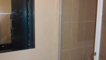 A bathroom with a white sink, a mirror, and a shower with a glass door.