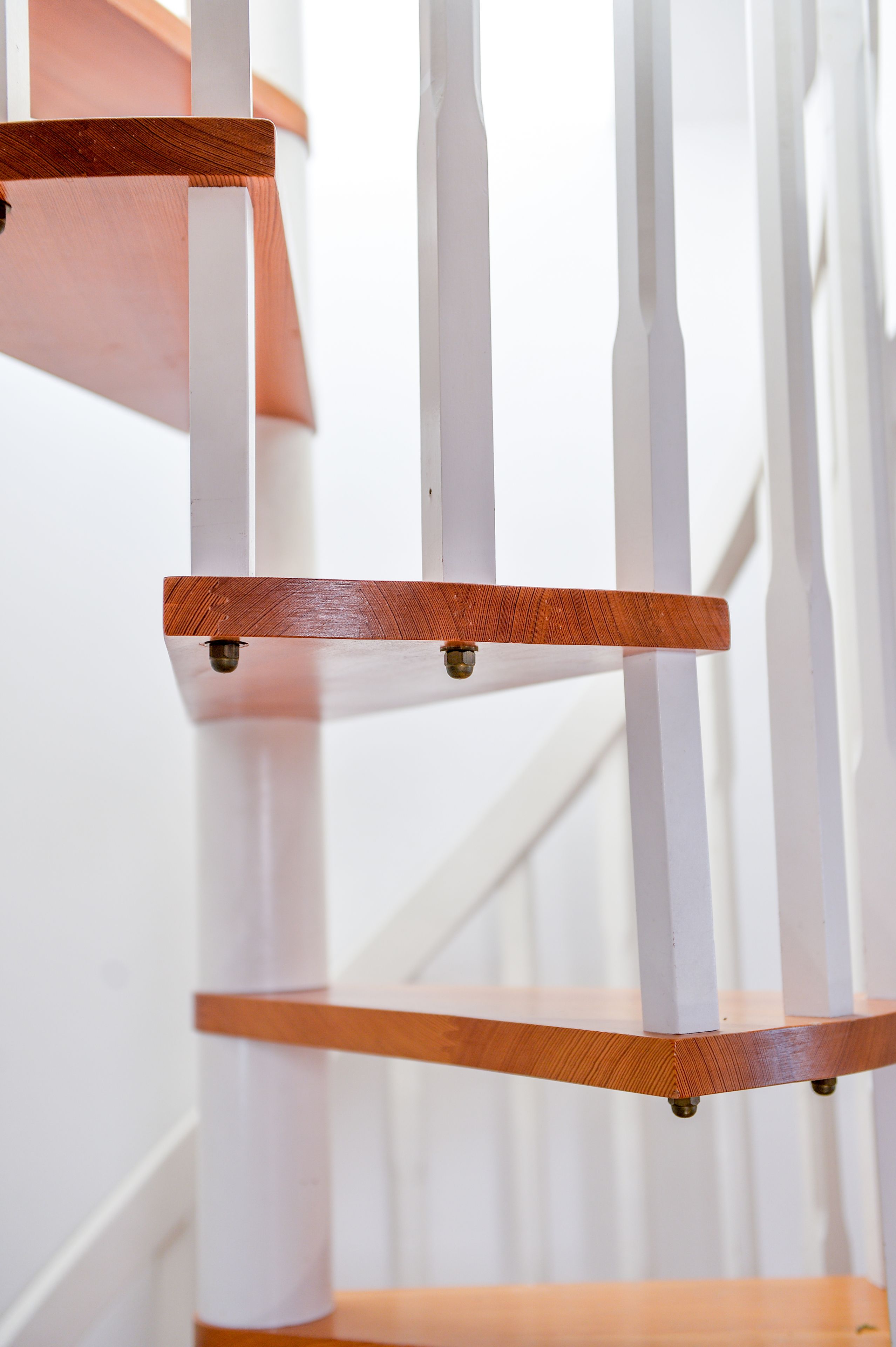 A wooden chair with a white backrest and a wooden seat.