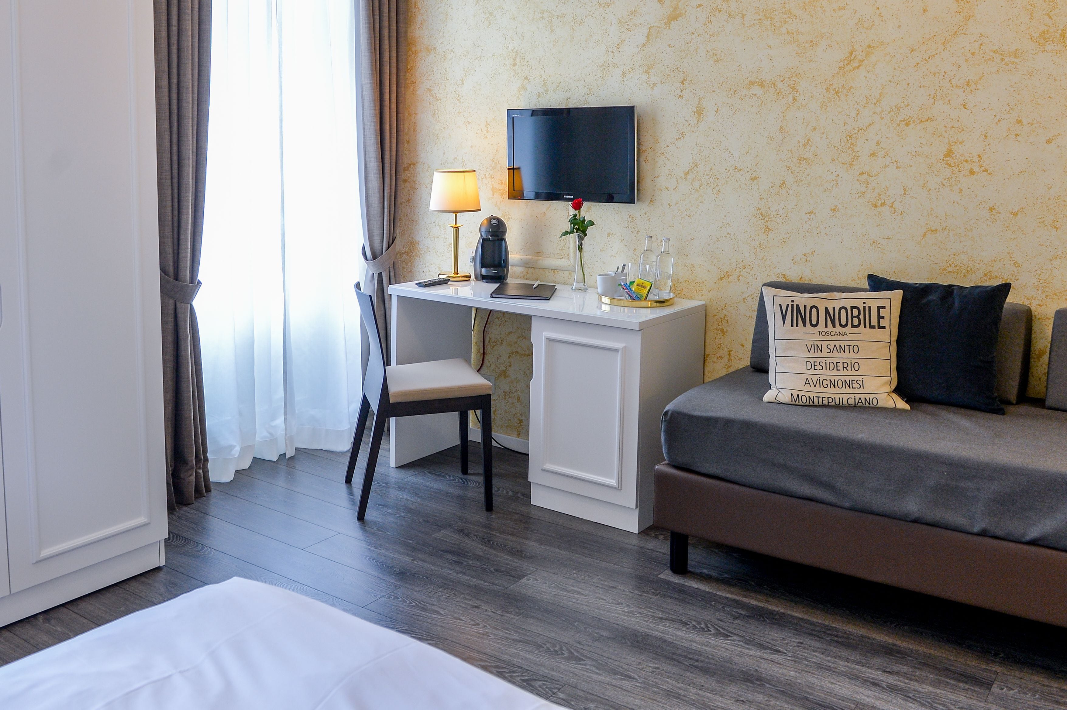 Ein Hotelzimmer mit Schreibtisch, Stuhl und Bett.