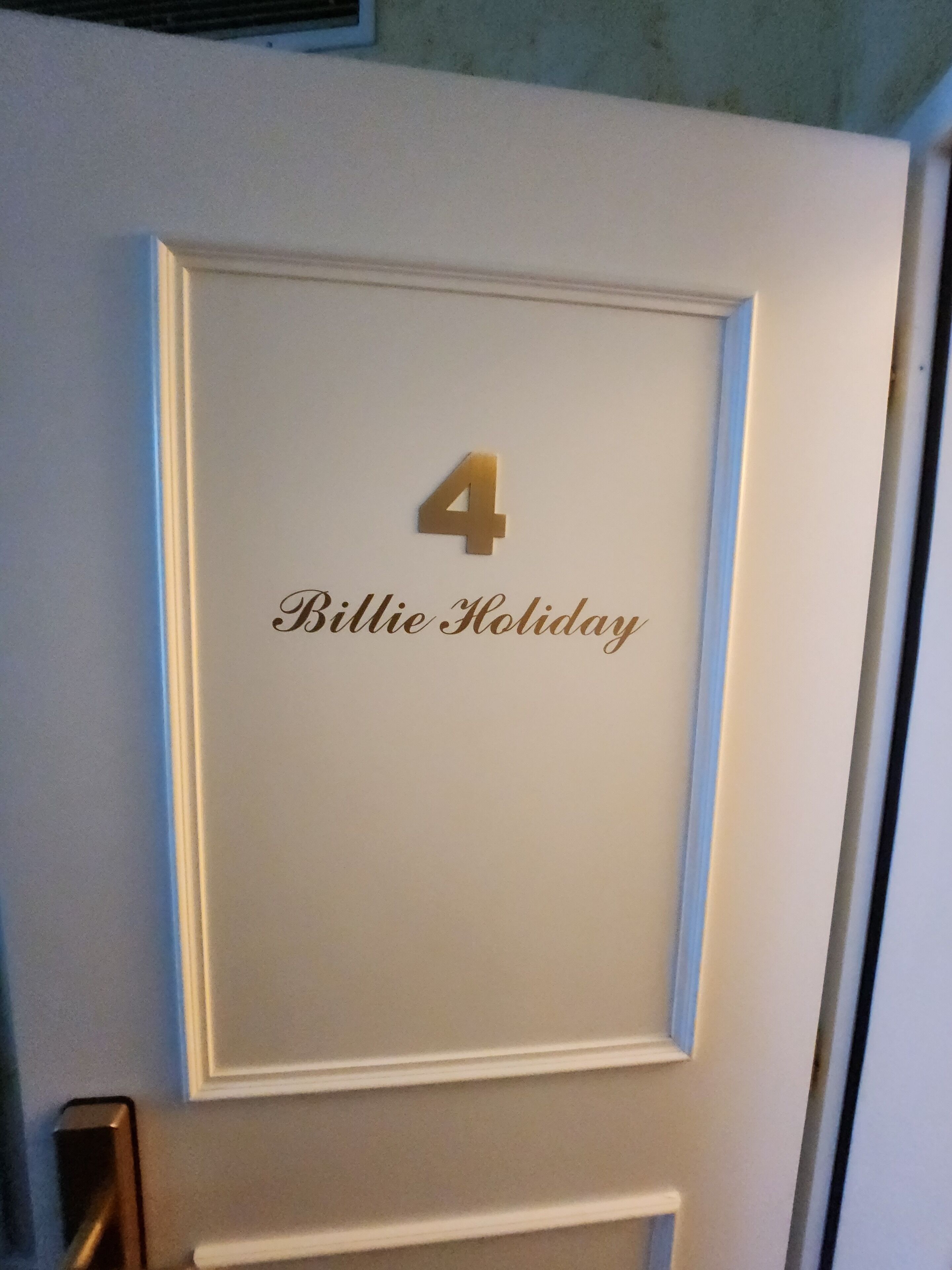 Een deur met een bordje met de tekst '4 Billie Holiday'.