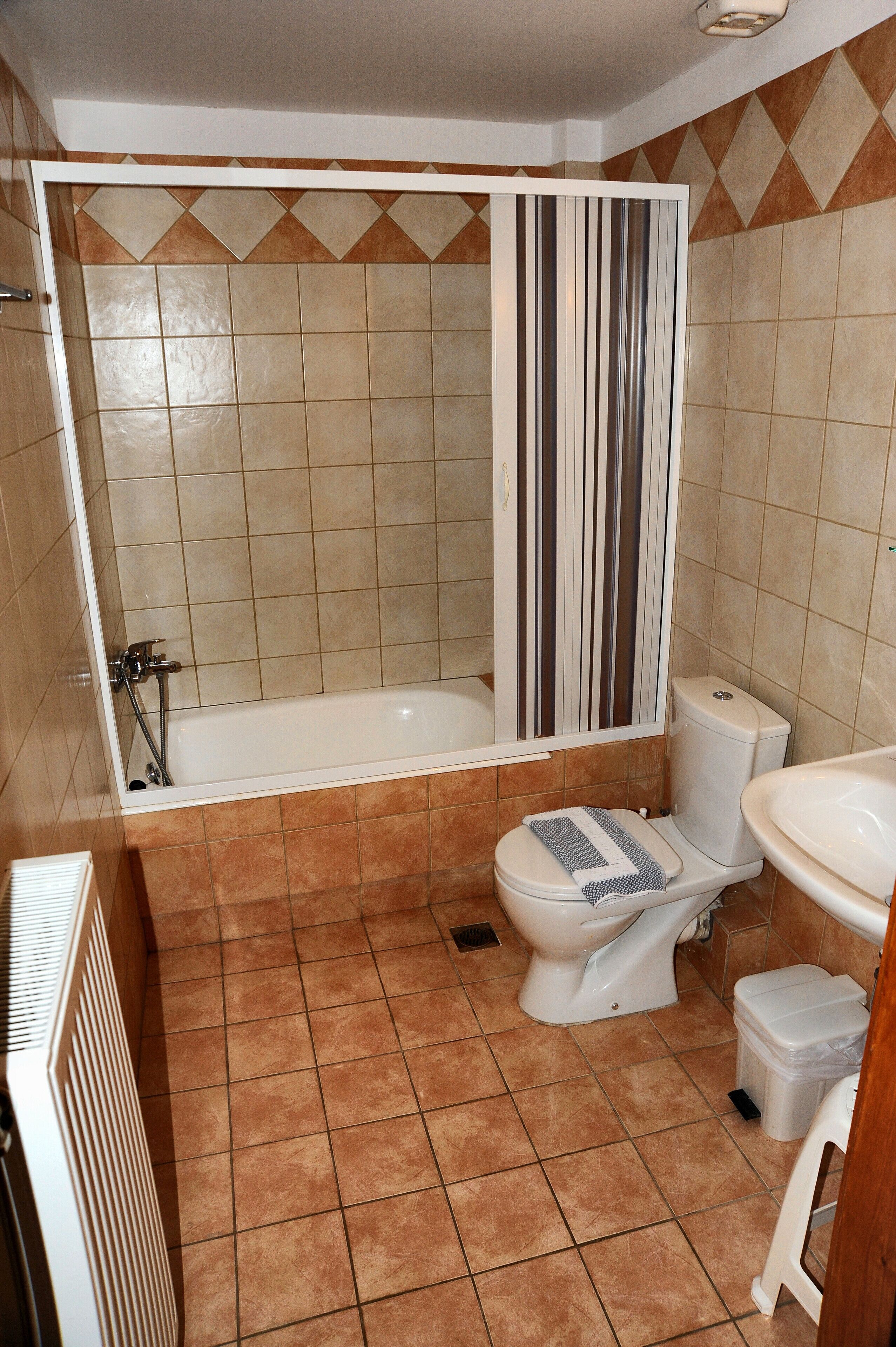 A bathroom with a bathtub, toilet, and sink.