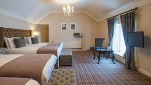 A hotel room with a large bed, a smaller bed, a sofa, a table, a TV, and a window with curtains. - Dooly's Hotel  (Birr)