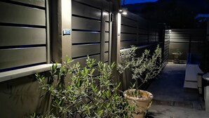 Ein durch einen Zaun gesicherter Weg mit Kübelpflanzen und einem Schild, das auf ein Rauchverbot hinweist.