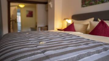 Una cama con ropa de cama a rayas y un cabecero con almohadas.