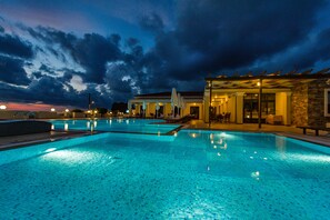 Una piscina al aire libre, sillones reclinables de piscina