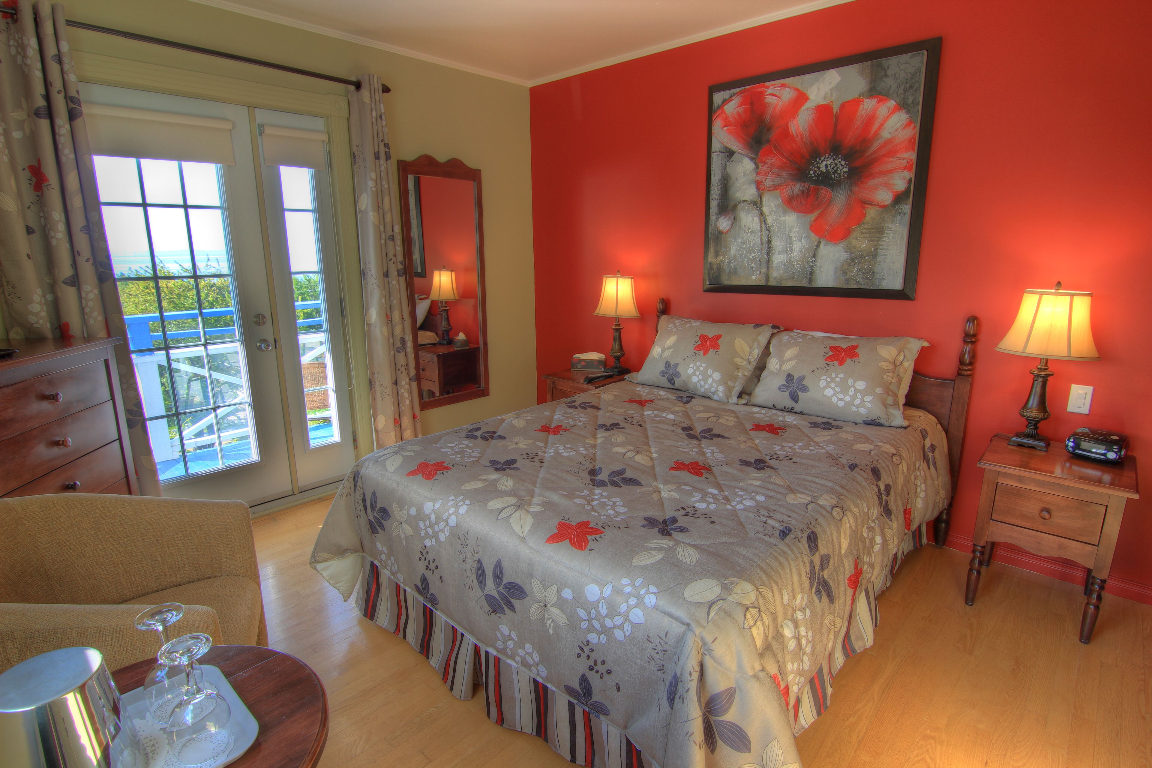 A bedroom with a bed, two bedside tables, a dresser, and a chair.