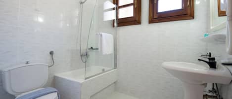 A bathroom with a toilet, a glass-enclosed shower, a bathtub, and a pedestal sink.
