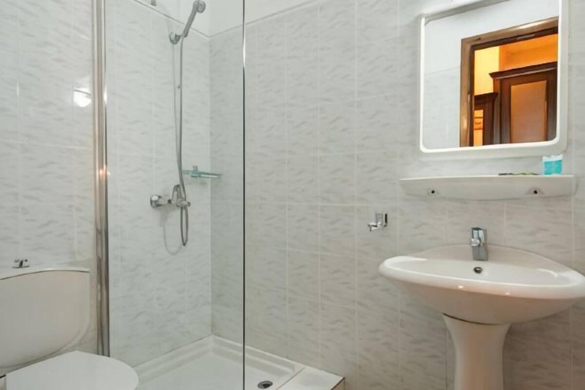 Badkamer | Een bad/douchecombinatie, gratis toiletartikelen, een haardroger