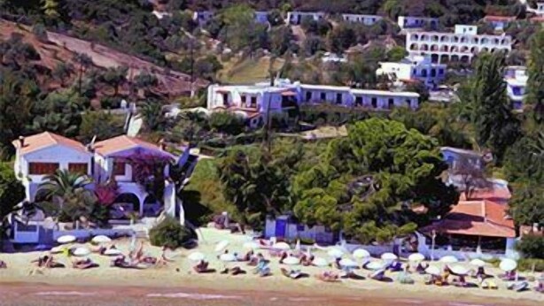 Una zona costera con playa, villas y vegetación exuberante.