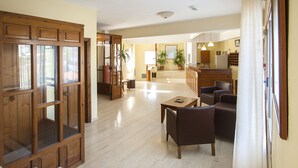Un amplio espacio de estar con una puerta de madera, una mesa de comedor y dos sofás.