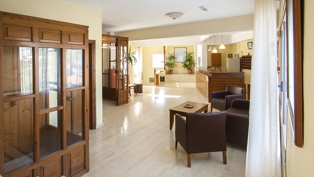 A spacious living area with a wooden door, a dining table, and two sofas. - Vontzos (Skiathos)