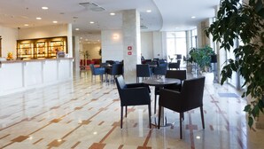 Un lobby amplio con una zona de bar moderna, disposiciones para sentarse y un suelo pulido.