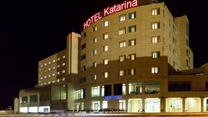 Un hotel de varios pisos con un llamativo letrero que dice 'HOTEL Katarina'.