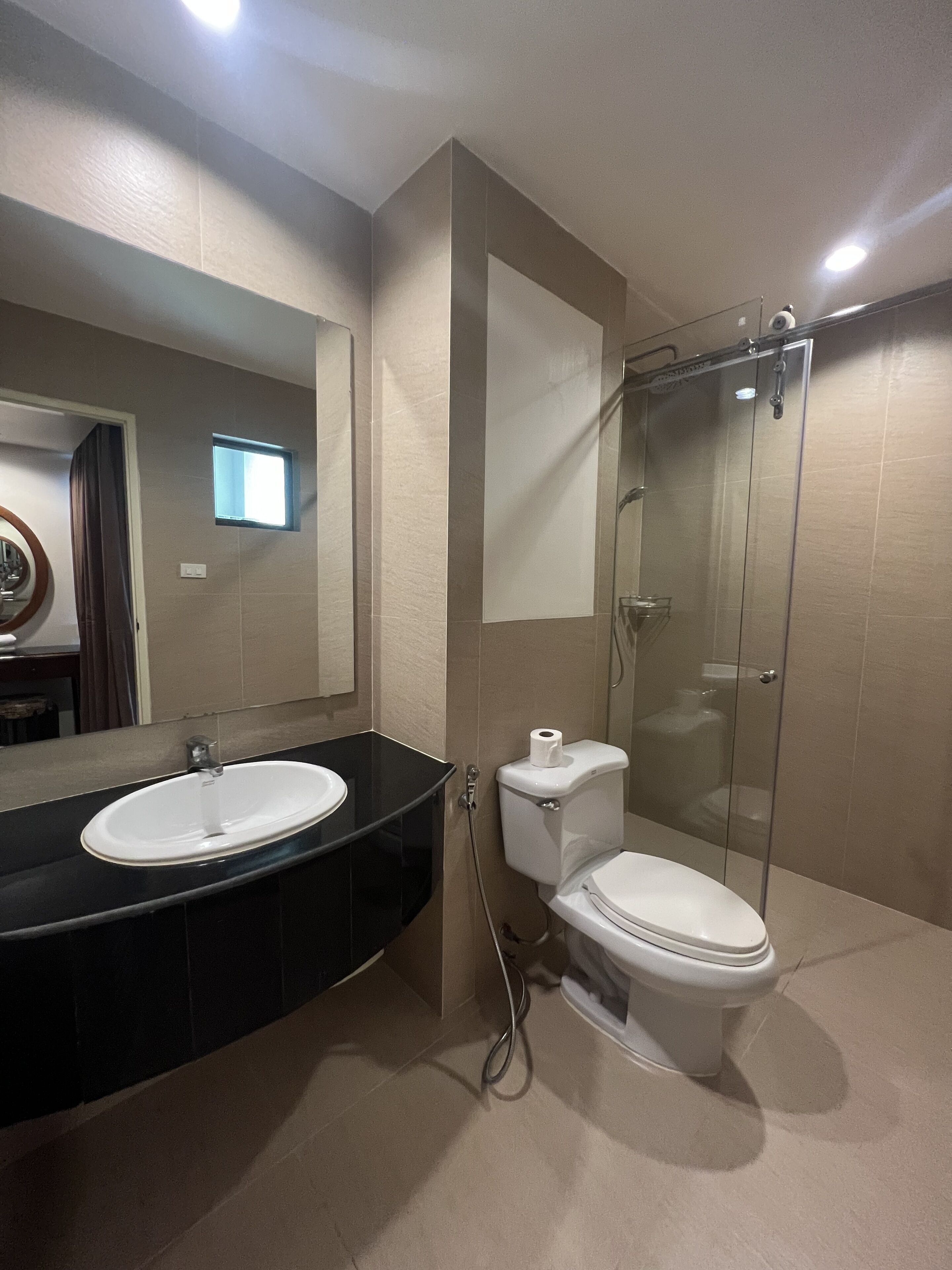 A bathroom with a sink, toilet, and glass shower enclosure.
