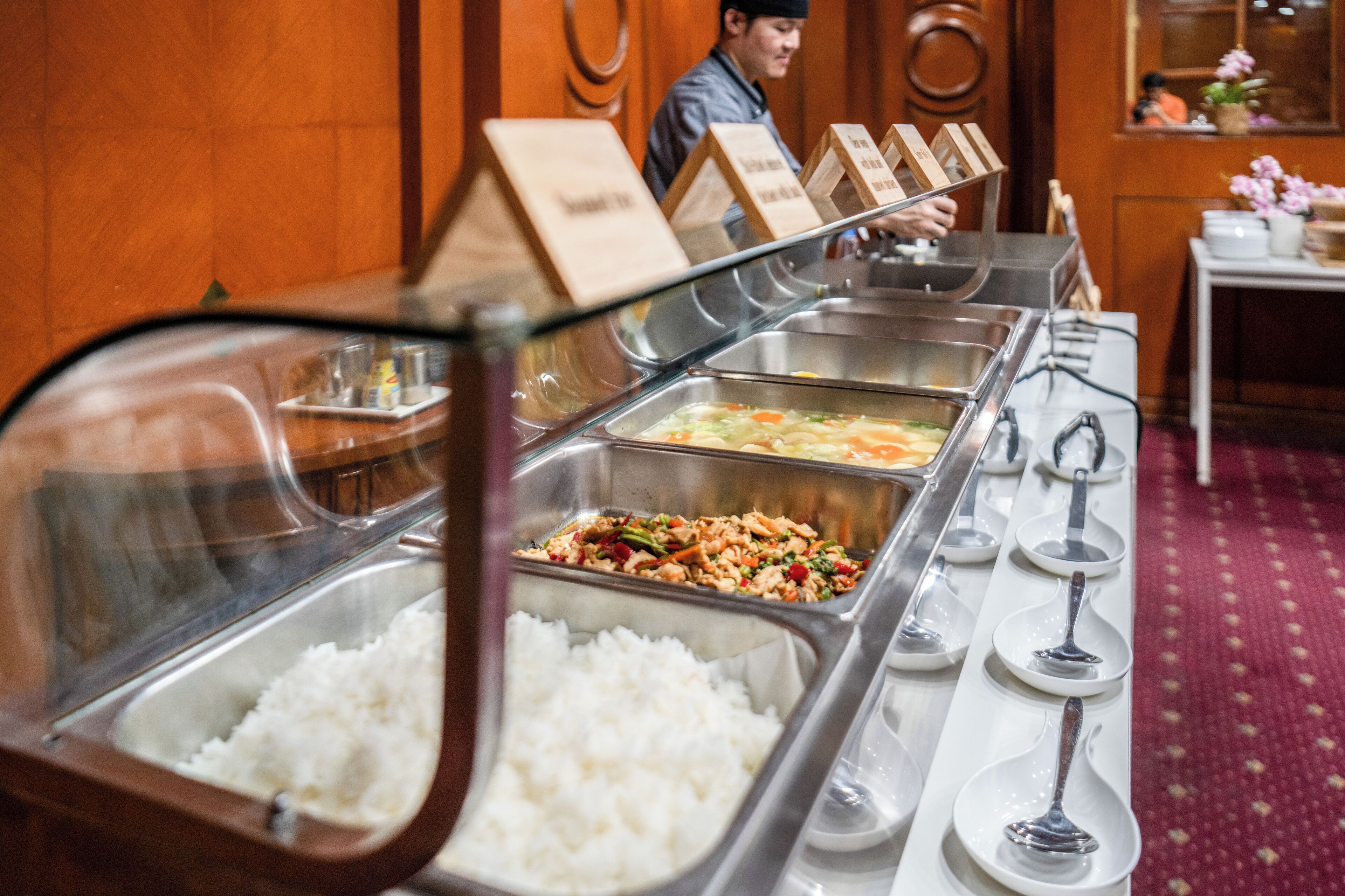 A buffet with various food options including rice, vegetables, and rice dishes.